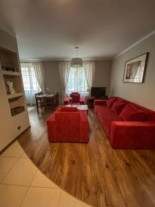 een woonkamer met een rode bank en een tafel bij Apartament Przy Długosza in Sandomierz
