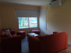 un soggiorno con 2 divani e una finestra di Melo 2203 Duplex 1 a Belén de Escobar