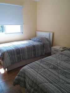 a bedroom with two beds and a window at Melo 2203 Duplex 1 in Belén de Escobar