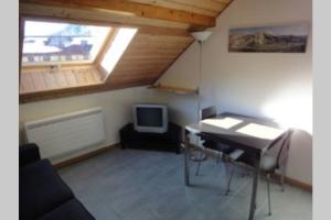 Cette chambre comprend un bureau et une télévision. dans l'établissement Loue studio de vacances rénové à Névache, à Névache