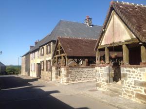 an old stone building on the side of a street at Gite Auvraysien 10p in La Forêt-Auvray