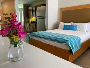 1 dormitorio con 1 cama y un jarrón de flores sobre una mesa en Divi Flamingo Beach Resort, en Kralendijk