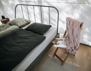 uma cama e uma cadeira ao lado de uma janela em Uz salas em Dagda