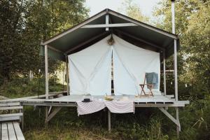 une tente avec une table et des chaises dans un champ dans l'établissement Uz salas, à Dagda