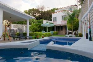 a swimming pool in front of a house at Preciosa Casa Maya Alberca y Jacuzzi Jiutepec Cuernavaca in Jiutepec