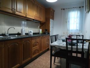 a kitchen with wooden cabinets and a table with a sink at Apartamentos Carlota in Puerto del Carmen