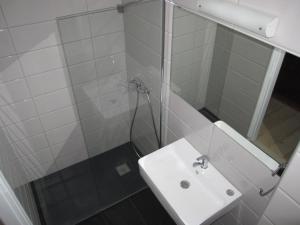 a white bathroom with a sink and a shower at Tina Hotel in Dassia