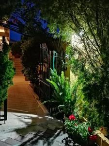 ogród z bramą oraz roślinami i kwiatami w obiekcie Domos Le Due Tuie w mieście Piscinas