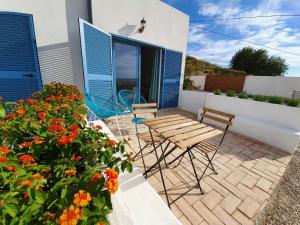 un patio con tavolo, sedie e fiori di B&B La Nava Suites a Mojácar