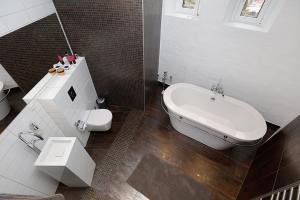 a bathroom with a tub and a toilet and a sink at Ystads Gamla Vattentorn in Ystad