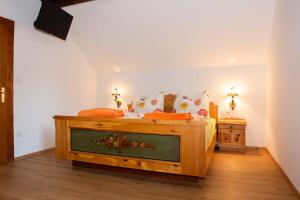 グミュント・イン・ケルンテンにあるHansbauer Appartmentsのベッドルーム1室(オレンジ色の枕が付いたベッド1台付)