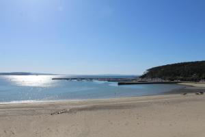 a sandy beach with a pier in the water at L'Imprenable vue mer in Crozon