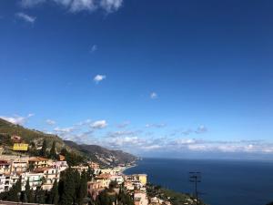 vista su una collina su una città e sull'oceano di TAORMINA CENTER APARTMENT with sea view a Taormina