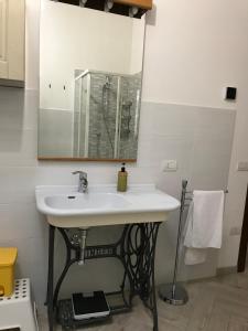 Alle case il pozzetto في سوفيريتو: حمام مع حوض أبيض ومرآة