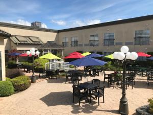 un patio con mesas, sillas y sombrillas en Powell River Town Centre Hotel, en Powell River