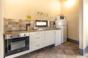 a kitchen with a sink and a refrigerator at Poggio La Croce in Scarlino