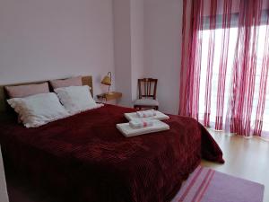 a bedroom with a bed with two towels on it at Casa da Praia em Porto Côvo in Porto Covo