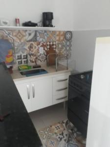 uma cozinha com um lavatório e um fogão em Apto Sao Vicente em São Vicente