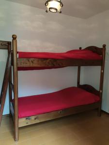 two bunk beds in a room with red sheets at Appartamento Vacanza a Santa Brigida( BG) in Santa Brigida