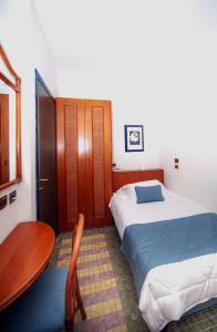 a bedroom with two beds and a table and a table at Hotel Della Baia in Portovenere