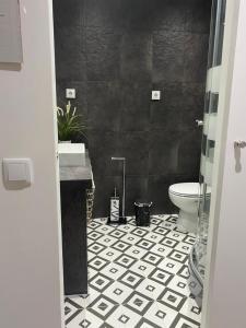 baño con aseo y pared negra en Belém River Apartment II en Lisboa