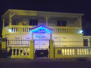a white building with a gate with lights on it at Villa Mancina in Capesterre-Belle-Eau