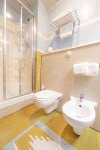 a bathroom with a toilet and a sink and a shower at Hotel Della Baia in Portovenere