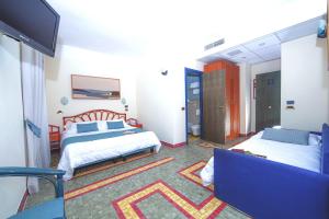 a hotel room with two beds and a tv at Hotel Della Baia in Portovenere