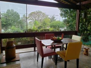 a dining room with a table and chairs and a large window at " Seu Cantinho" in Gravatá