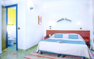 a bedroom with a bed and a bathroom with a tub at Hotel Della Baia in Portovenere