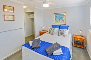 um quarto com uma cama grande e lençóis azuis em By The Beach Relaxs - 3 Beds 2 Bath-Pool-Tennis-Golf em Marcoola