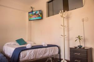 a bedroom with a bed with a tv on the wall at APARTMENT FOR GROUP Miraflores in Lima