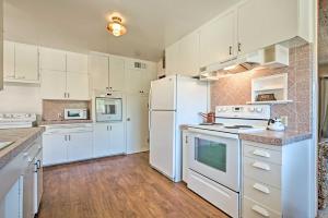 a white kitchen with white appliances and wooden floors at Scenic Kernville Home - Walk to Downtown and River! in Kernville