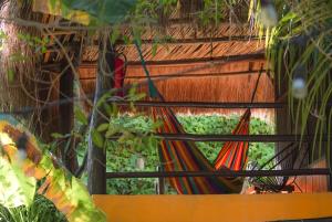 a hammock in front of a building with plants at Tunich Jungle Cabañas in Tulum +32 photos