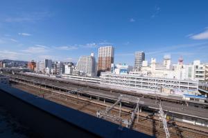 Blick auf eine Stadt mit Zuggleisen und Gebäuden in der Unterkunft Grand Hotel Kanachu Hiratsuka in Hiratsuka