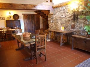 Casa da Bica Gondesende في براغانزا: غرفة طعام مع طاولة وجدار حجري