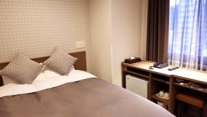 1 dormitorio con 1 cama y ventana con teléfono en Hotel Sun Royal Utsunomiya en Utsunomiya