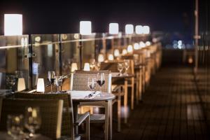a row of tables and chairs with wine glasses at Shilla Stay Jeju in Jeju