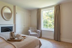 - une chambre avec un lit, une chaise et une fenêtre dans l'établissement Hill House Farm by Bloom Stays, à Canterbury