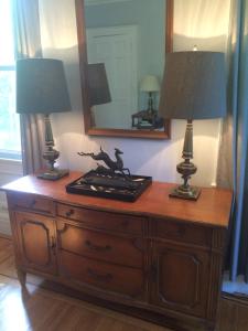 two lamps on top of a wooden dresser with a mirror at Gardner Farm Inn in Troy