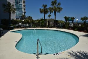 a swimming pool in a resort with palm trees at Ocean Dream Vacation in Myrtle Beach