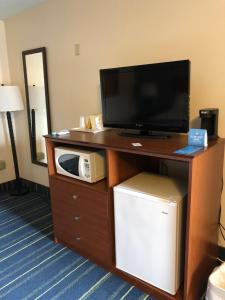 a tv on a wooden stand with a microwave at Days Inn by Wyndham Breezewood in Breezewood