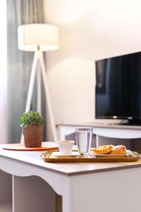 a table with a plate of food and a television at Areti InCreteble Cretan Residences Collection in Sitia