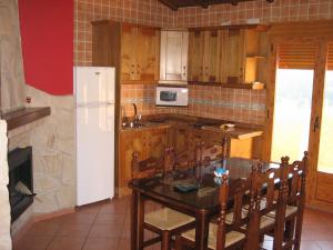 a kitchen with a table and a white refrigerator at Alojamientos Bellavista in Coto Ríos