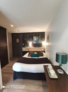 een hotelkamer met een groot bed en een tafel bij Celtic Hotel in Auray