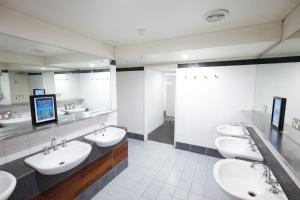 a bathroom with two sinks and two mirrors at Melbourne Metro YHA in Melbourne