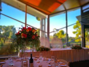 una mesa con un jarrón de flores. en Renmark Country Club, en Renmark