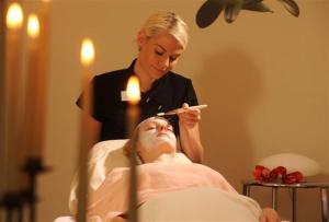 Una donna che spazzola la faccia di un uomo in una stanza d'ospedale di Hotel am Schlosspark a Gotha