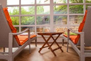 two chairs and a table in front of a window at Hotel am Schlosspark in Gotha