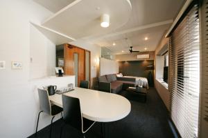 a room with a white table and chairs and a couch at ZONK HOTEL Nakasu in Fukuoka